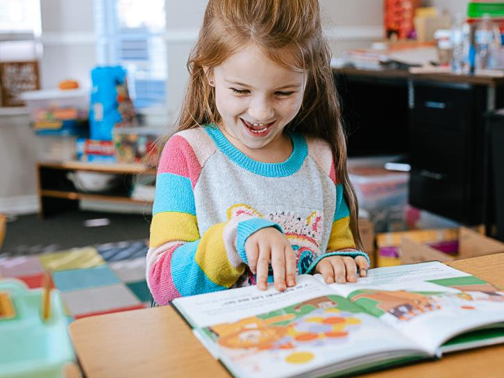 Little girl reading a Generous Family storybook in her room, Christian children’s book about kindness and compassion.