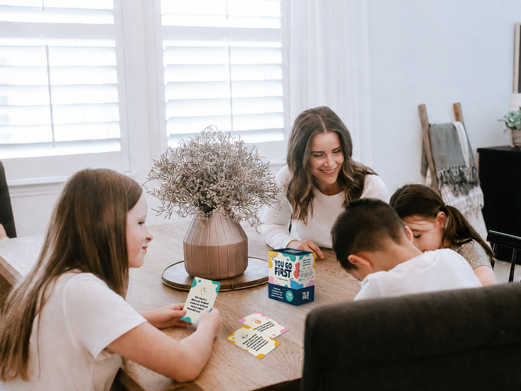 Family playing You Go First Christian conversation cards together at the dinner table